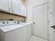 Laundry room with full size washer and dryer and ample cabinet storage at 860 Wolf Creek St, Clermont, FL 34711