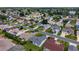 Aerial view shows a home with a screened lanai among lush green landscaping at 870 Danforth Ct, The Villages, FL 32162