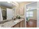 Bathroom vanity with granite countertop, framed mirror, and access to shower and bedroom at 870 Danforth Ct, The Villages, FL 32162