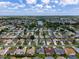 Aerial view of the community features many homes, green spaces, and a lake at 870 Danforth Ct, The Villages, FL 32162