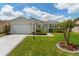 Charming single-story home with well-maintained landscaping and an attached garage at 870 Danforth Ct, The Villages, FL 32162