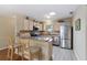 Well-lit kitchen with stainless steel appliances, a breakfast bar, and modern countertops at 870 Danforth Ct, The Villages, FL 32162