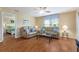 Comfortable living room with leather sofas, glass table, ceiling fan and view into the main bedroom at 870 Danforth Ct, The Villages, FL 32162