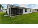 View of the screened porch with chairs and view of the lawn at 870 Danforth Ct, The Villages, FL 32162