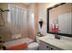 Bright bathroom with a large framed mirror, shower with tub, and white marble countertop at 879 Lucky Ln, The Villages, FL 32162