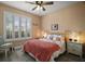 Inviting bedroom with a decorative bedspread, window with shutters, and neutral walls at 879 Lucky Ln, The Villages, FL 32162