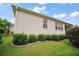 Home exterior showcasing lush landscaping with manicured bushes and well-kept lawn at 879 Lucky Ln, The Villages, FL 32162