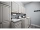Laundry room featuring washer, dryer, utility sink and storage cabinets, offering convenience and functionality at 879 Lucky Ln, The Villages, FL 32162