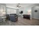 Comfortable living space with hardwood flooring, large windows, and a cozy atmosphere at 879 Lucky Ln, The Villages, FL 32162