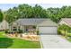 Charming single-story home with a well-manicured lawn, lush landscaping, and a two-car garage at 1061 Soledad Way, The Villages, FL 32159
