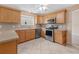 Well-equipped kitchen with stainless steel appliances, ample cabinet space, and light-colored tile flooring at 1061 Soledad Way, The Villages, FL 32159