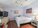 Comfortable bedroom with hardwood floors, light purple walls, and natural light at 1105 Del Toro Dr, The Villages, FL 32159