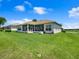 Spacious backyard with lush lawn, screened porch, and golf course view at 11702 Se 173Rd Lane Rd, Summerfield, FL 34491