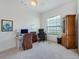 Bright bedroom with a ceiling fan, a desk with computer, and a curio cabinet at 11702 Se 173Rd Lane Rd, Summerfield, FL 34491