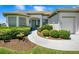 Inviting front entrance with manicured landscaping, a paved walkway, and a charming front door at 11702 Se 173Rd Lane Rd, Summerfield, FL 34491