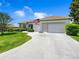 This beautiful home features lush landscaping, a two-car garage, and a well-manicured lawn at 11702 Se 173Rd Lane Rd, Summerfield, FL 34491