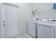 Bright laundry room with white washer and dryer and a wire shelf at 11702 Se 173Rd Lane Rd, Summerfield, FL 34491