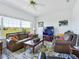 Comfortable living room with leather furniture, large windows, and stylish decor at 11702 Se 173Rd Lane Rd, Summerfield, FL 34491