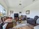 Living room with leather seating, a flat screen TV, and a ceiling fan at 11702 Se 173Rd Lane Rd, Summerfield, FL 34491