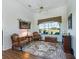 Cozy living room features a large window, comfortable seating, and decorative tapestry at 11702 Se 173Rd Lane Rd, Summerfield, FL 34491