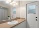 Bathroom showcasing a single vanity, large mirror, and a door leading to the outside at 11811 Ridge View Cir, Clermont, FL 34711