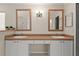 Bathroom featuring a double sink vanity with white cabinets, stylish lighting, and framed mirrors at 11811 Ridge View Cir, Clermont, FL 34711