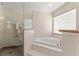 Bathroom featuring a soaking tub with tiled steps and a glass door shower at 11811 Ridge View Cir, Clermont, FL 34711