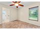 Bright bedroom featuring tile floors, a ceiling fan, and a window letting in natural light at 11811 Ridge View Cir, Clermont, FL 34711