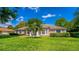Beautiful home featuring well-maintained landscaping with palm trees and large windows for natural light at 11811 Ridge View Cir, Clermont, FL 34711