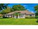 Charming single-story home with manicured lawn, mature landscaping, and classic architectural details at 11811 Ridge View Cir, Clermont, FL 34711