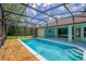 View of the enclosed pool with stone landscaping at 11811 Ridge View Cir, Clermont, FL 34711