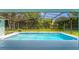 Relaxing screened-in pool area with lush greenery, perfect for outdoor entertainment at 11811 Ridge View Cir, Clermont, FL 34711