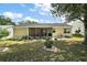 Exterior view of the home featuring a screened lanai and spacious backyard with mature landscaping at 1203 Zapata Pl, The Villages, FL 32159