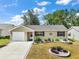 Charming single-story home featuring a well-manicured lawn, colorful landscaping, and an attached one car garage at 1203 Zapata Pl, The Villages, FL 32159