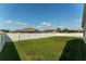 Large backyard featuring a well maintained lawn and tall, white vinyl privacy fence at 12054 Ne 51St Cir, Oxford, FL 34484