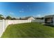 Large backyard featuring a well maintained lawn and tall, white vinyl privacy fence at 12054 Ne 51St Cir, Oxford, FL 34484