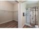 Bright bathroom featuring a stand up shower with patterned curtain and a large, open walk in closet at 12054 Ne 51St Cir, Oxford, FL 34484