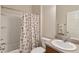 Bathroom features a shower-tub combination with seashell curtain, toilet, and vanity with sink at 12054 Ne 51St Cir, Oxford, FL 34484