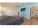 Vaulted ceiling primary bedroom with laminate flooring, TV, and ensuite bathroom at 12054 Ne 51St Cir, Oxford, FL 34484