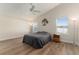 Spacious bedroom with vaulted ceiling, two windows with blinds, ceiling fan, and wood-look flooring at 12054 Ne 51St Cir, Oxford, FL 34484