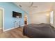 Primary bedroom featuring laminate flooring, TV, and ensuite bathroom at 12054 Ne 51St Cir, Oxford, FL 34484