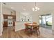 Cozy dining area with hardwood floors, chandelier, and view of the kitchen and sliding glass doors at 12054 Ne 51St Cir, Oxford, FL 34484