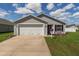 Attractive single-story home with a two-car garage, concrete driveway, and manicured lawn, radiating curb appeal at 12054 Ne 51St Cir, Oxford, FL 34484