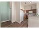 View of the kitchen showing the stainless refrigerator, white range, wood cabinets and flooring at 12054 Ne 51St Cir, Oxford, FL 34484