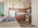Well-lit kitchen featuring wood cabinets, laminate countertops, white appliances, and wood-look flooring at 12054 Ne 51St Cir, Oxford, FL 34484