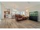 Open-concept living room with hardwood floors, ceiling fan, and views of the dining area and kitchen at 12054 Ne 51St Cir, Oxford, FL 34484