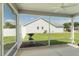View from screened lanai to backyard, including statue and lawn, perfect for enjoying the outdoors bug-free at 12054 Ne 51St Cir, Oxford, FL 34484