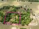 Aerial view highlighting the property's boundaries, lush tree coverage, and surroundings at 12196 Ne 4Th Pl, Oxford, FL 34484