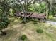 Aerial view of the property showing the home's location and surrounding landscaping, including mature trees and a lawn at 12196 Ne 4Th Pl, Oxford, FL 34484