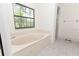 Bright bathroom with a jetted tub and a separate glass-enclosed shower at 12196 Ne 4Th Pl, Oxford, FL 34484